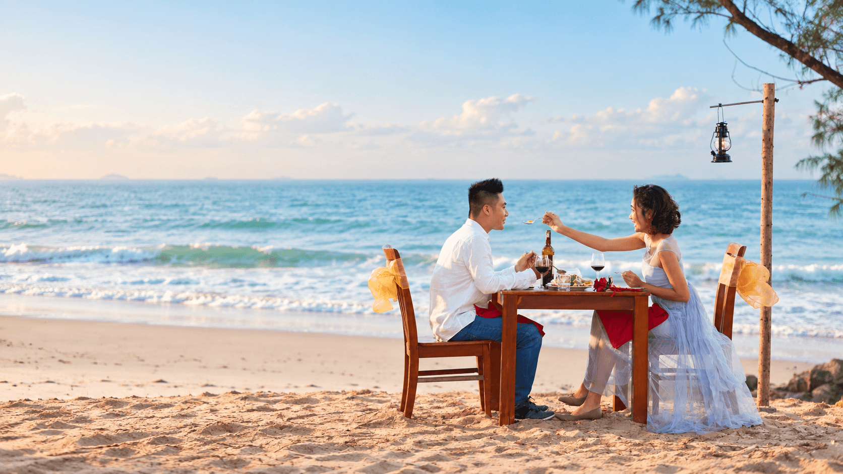 Couple celebrating their honeymoon by the sea at sunset